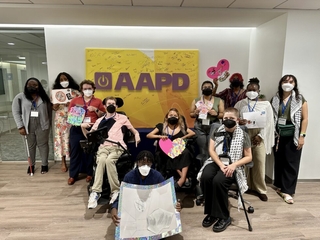 A group of students posing for the camera in front of AAPD's front office entrance.